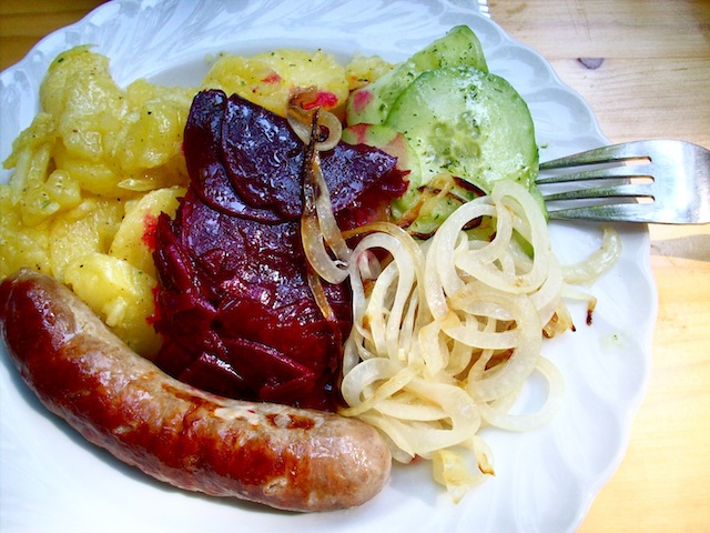 bratwurst with potato salad, beet salad, cucumber salad, and grilled onions (Eat Me. Drink Me.)